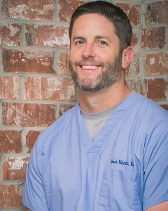 Dr. Shaun Mayatte smiling in blue scrubs